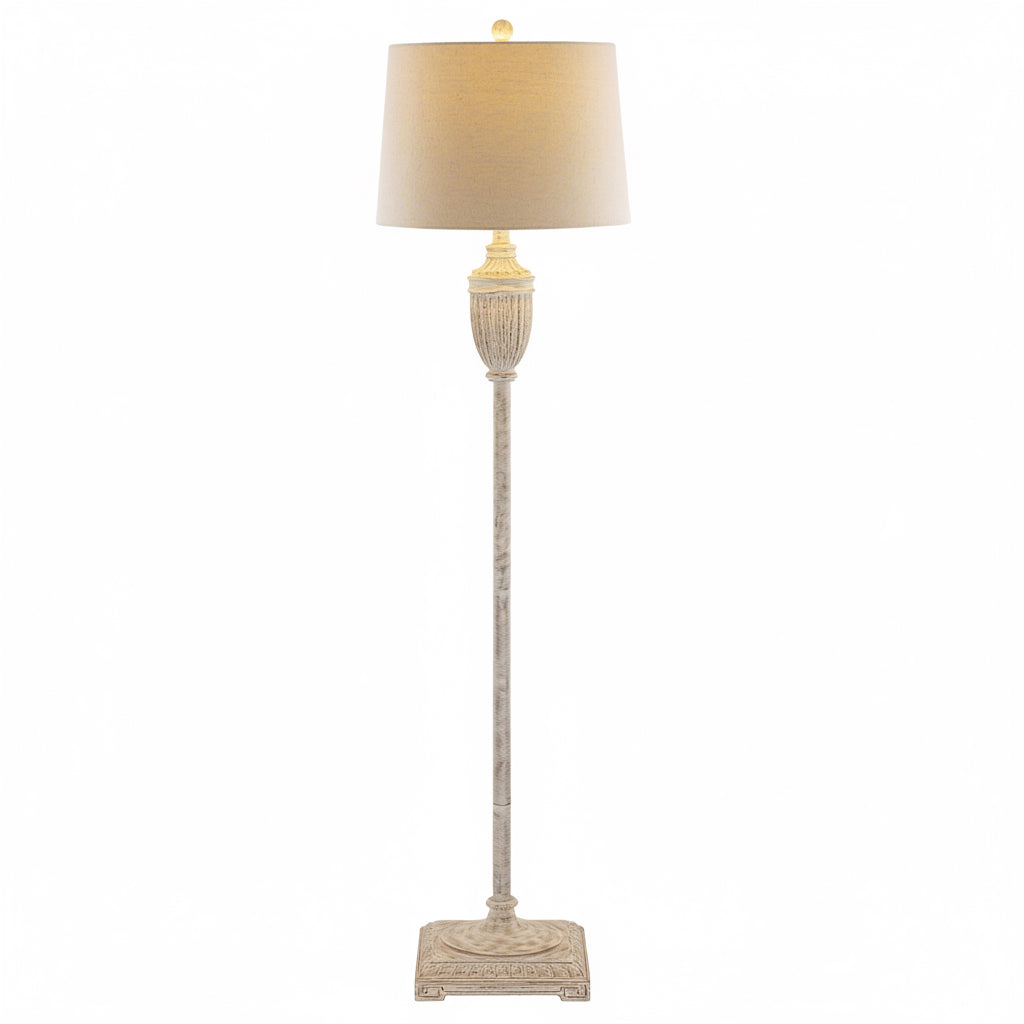 Floor lamp with decorative base and beige lampshade on a white background