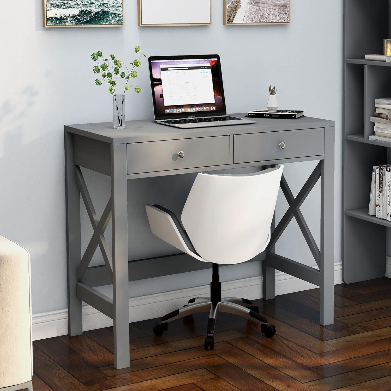 Gray desk with a laptop, chair, and decorative items in a home office setting.