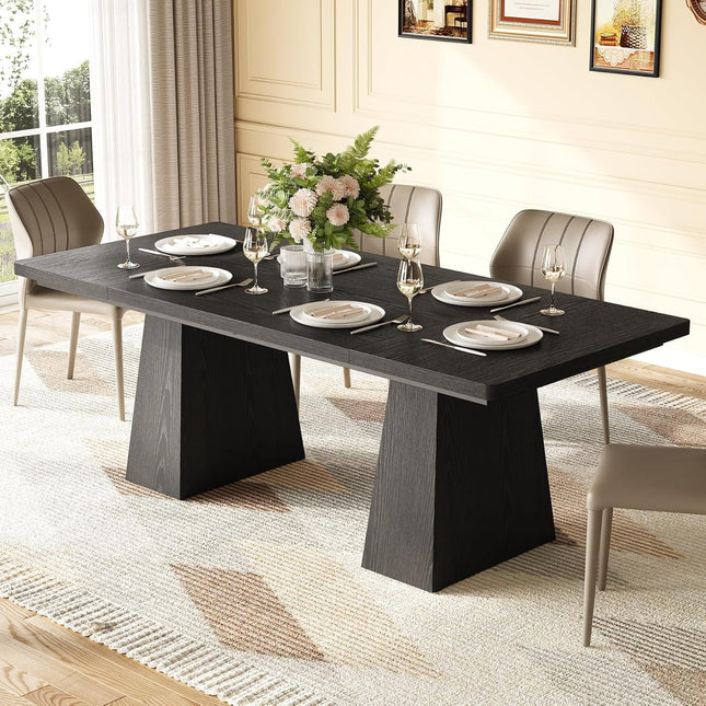 Dining table set with plates, glasses, and a floral centerpiece in a well-lit room.