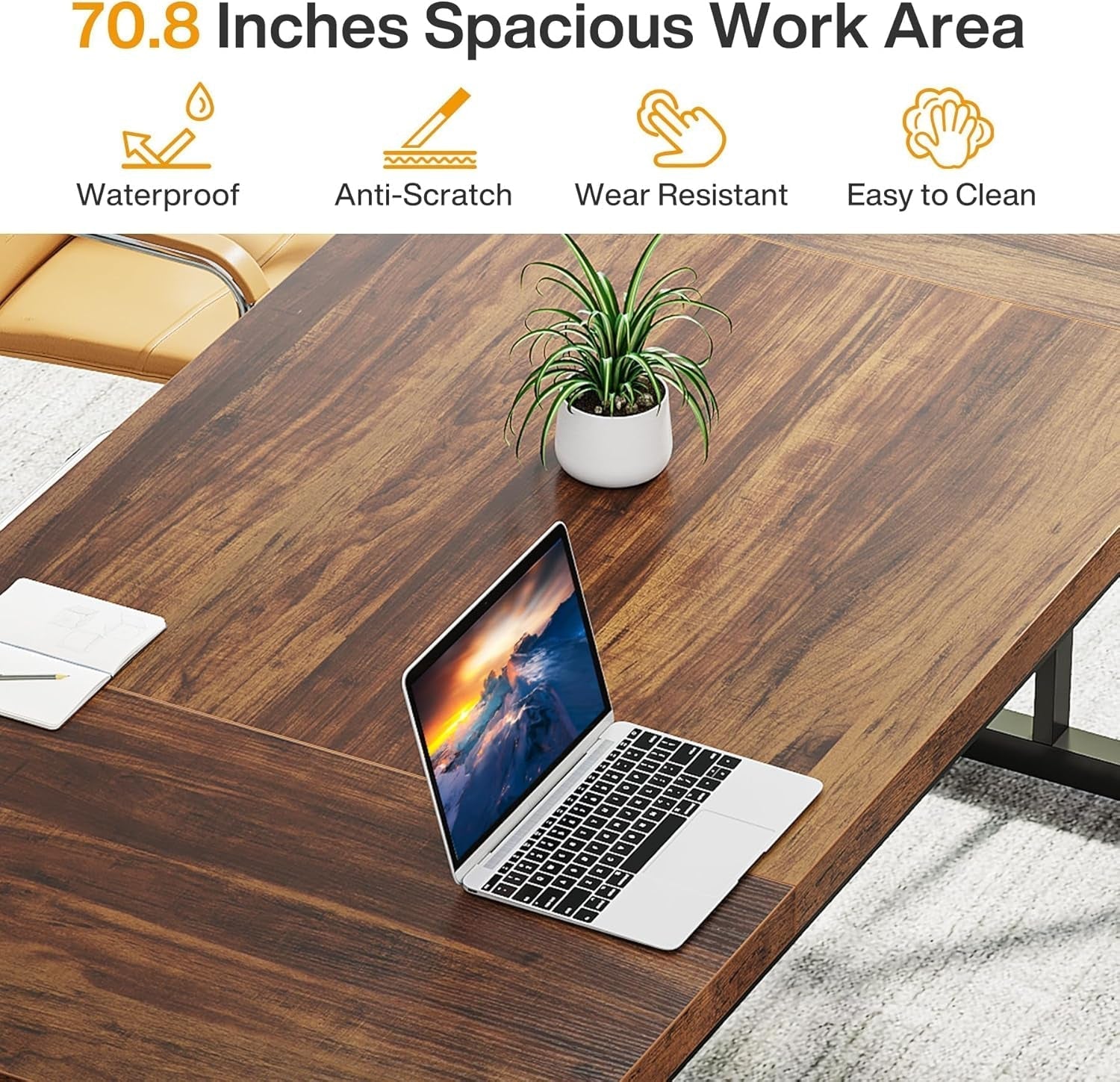 Wooden desk with a laptop, plant, and stationery items on a carpeted floor.