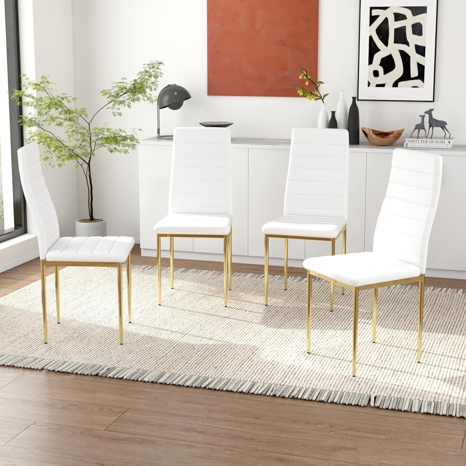 Modern dining room with white chairs with gold legs on a wooden floor.