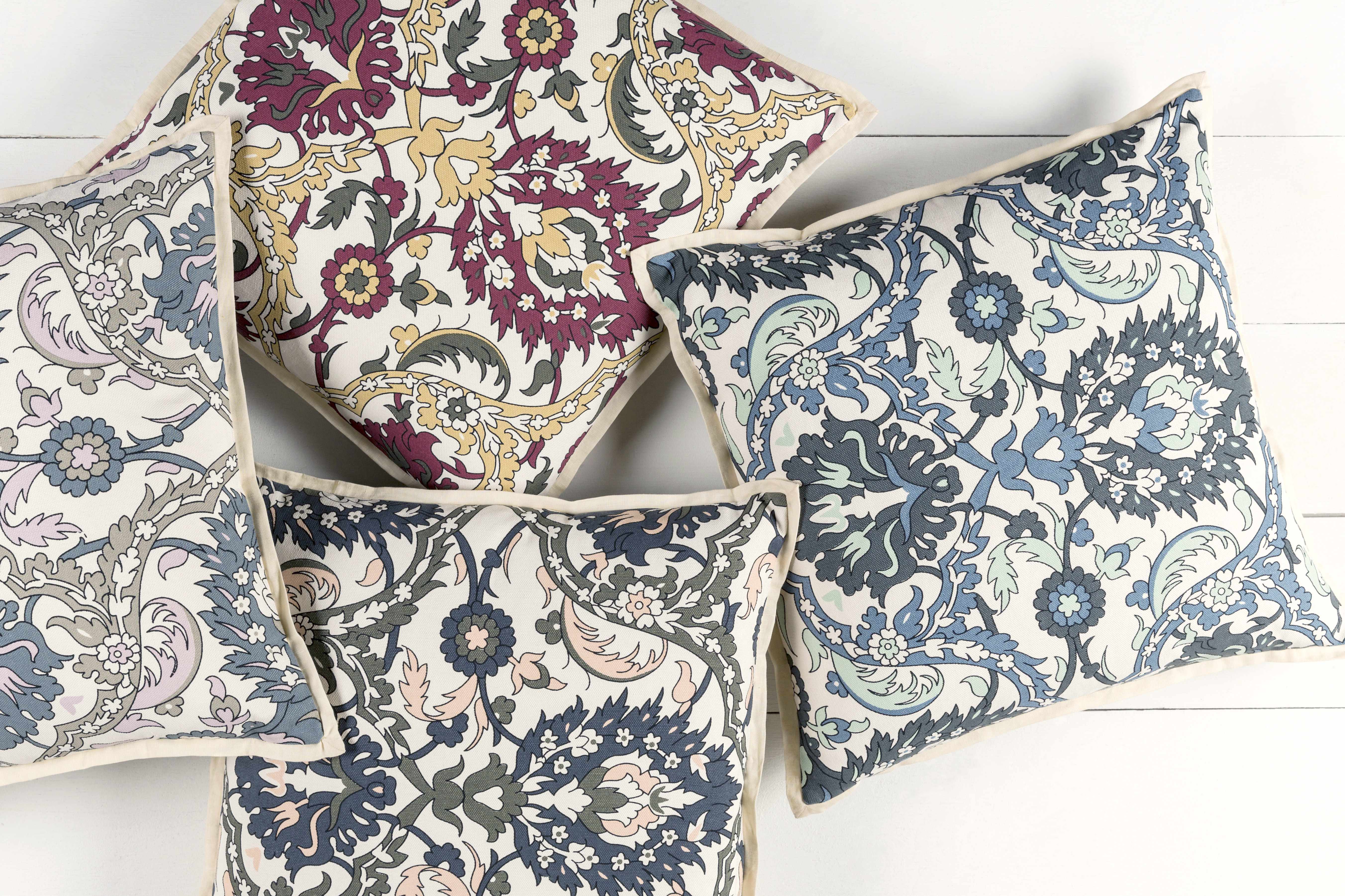 Set of floral patterned cushions on a white wooden surface