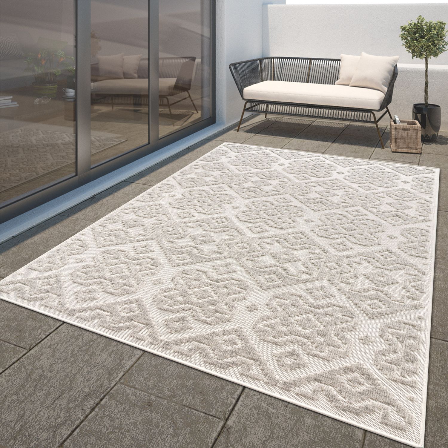 Patterned outdoor rug on a patio with furniture and glass doors in the background
