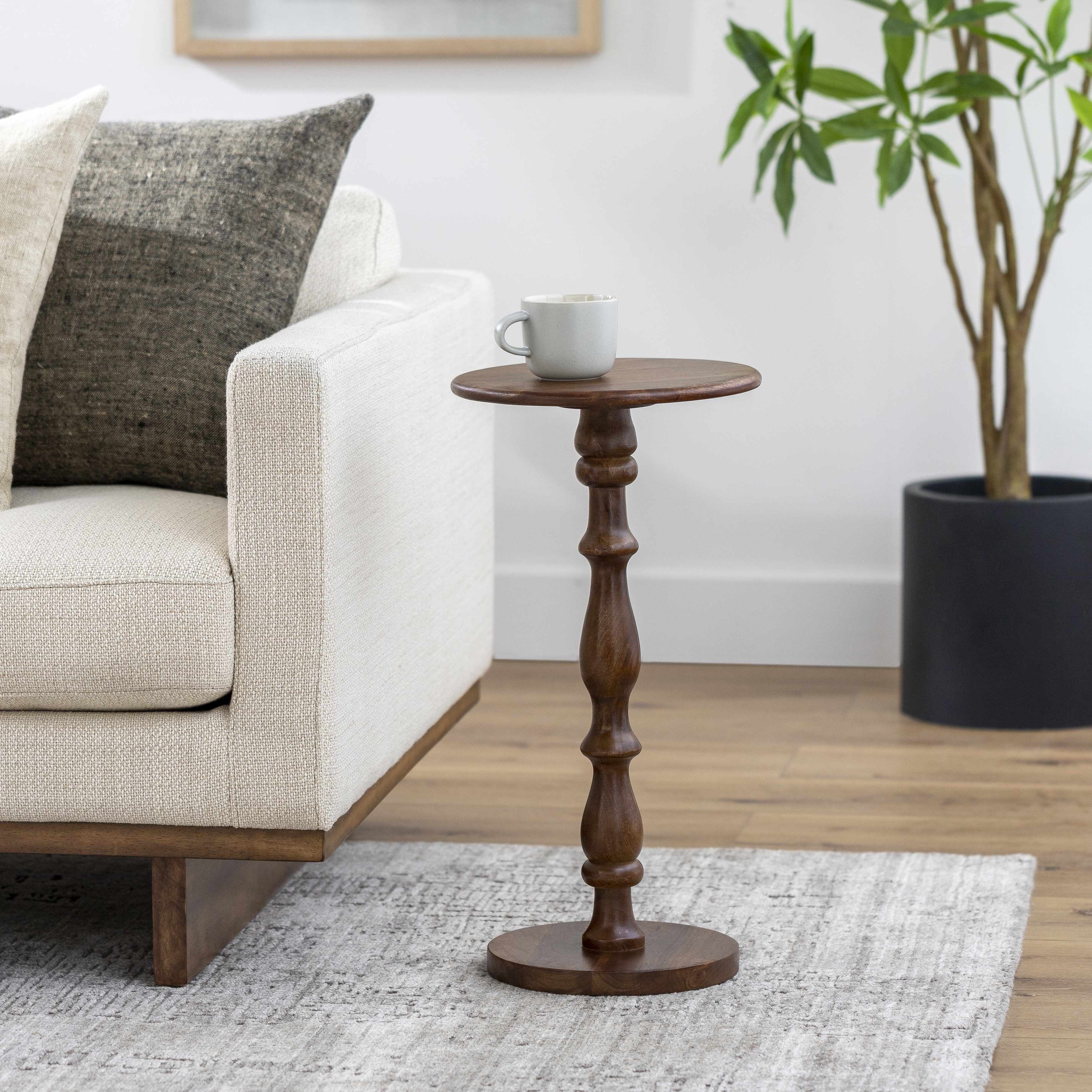 Wooden side table with a cup on it in a living room setting
