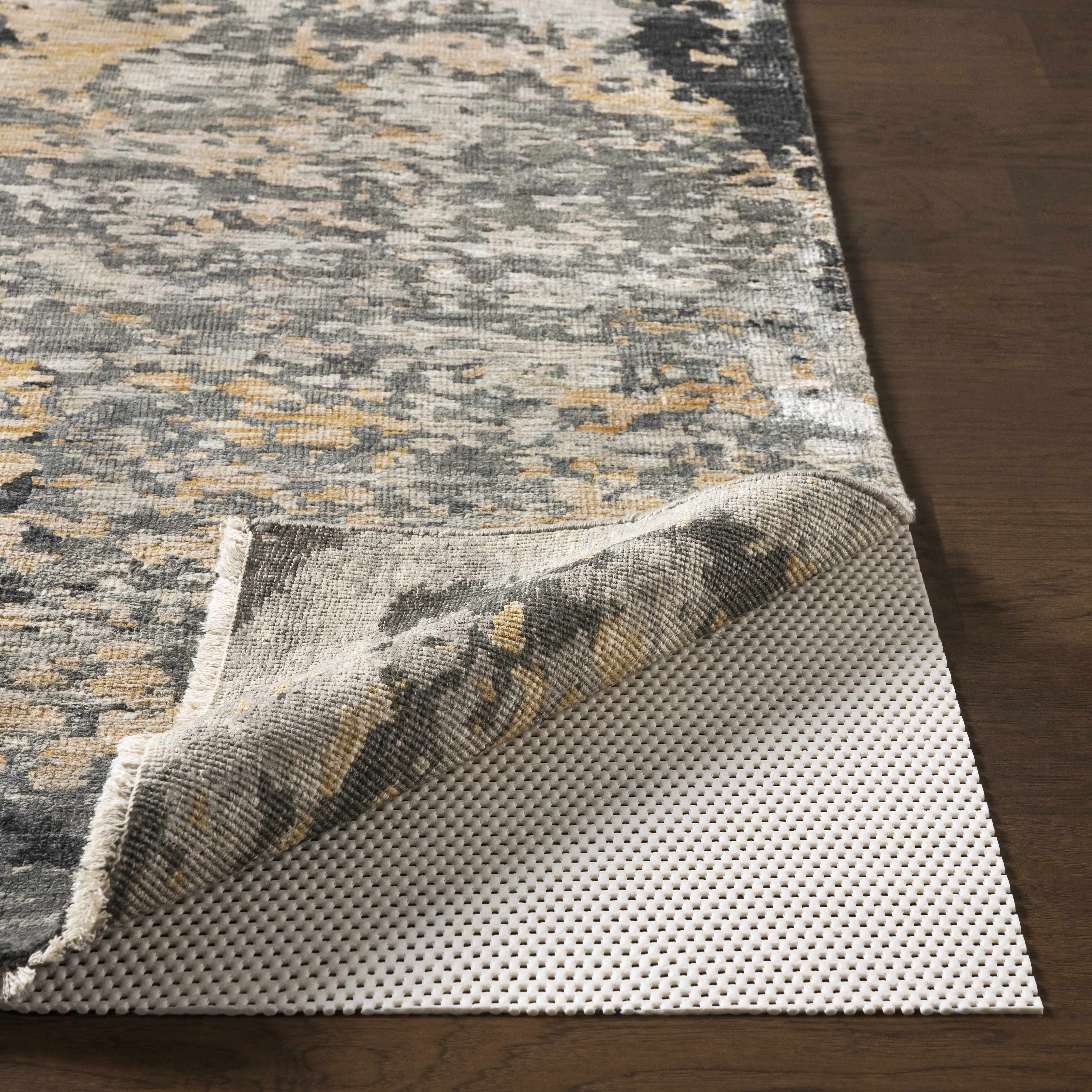 Patterned rug on a wooden floor with a protective underlay