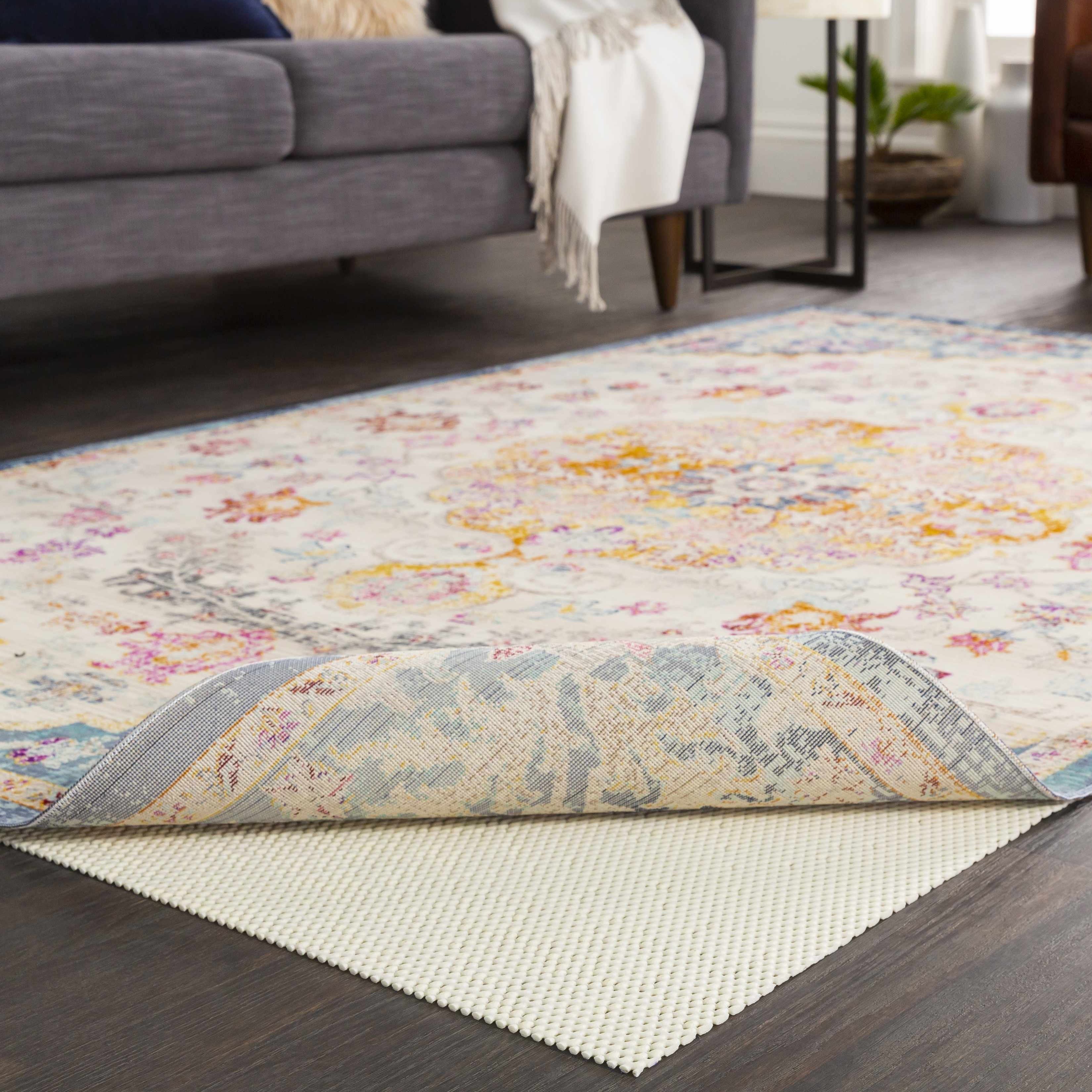 Floral patterned rug on a wooden floor with a gray sofa in the background