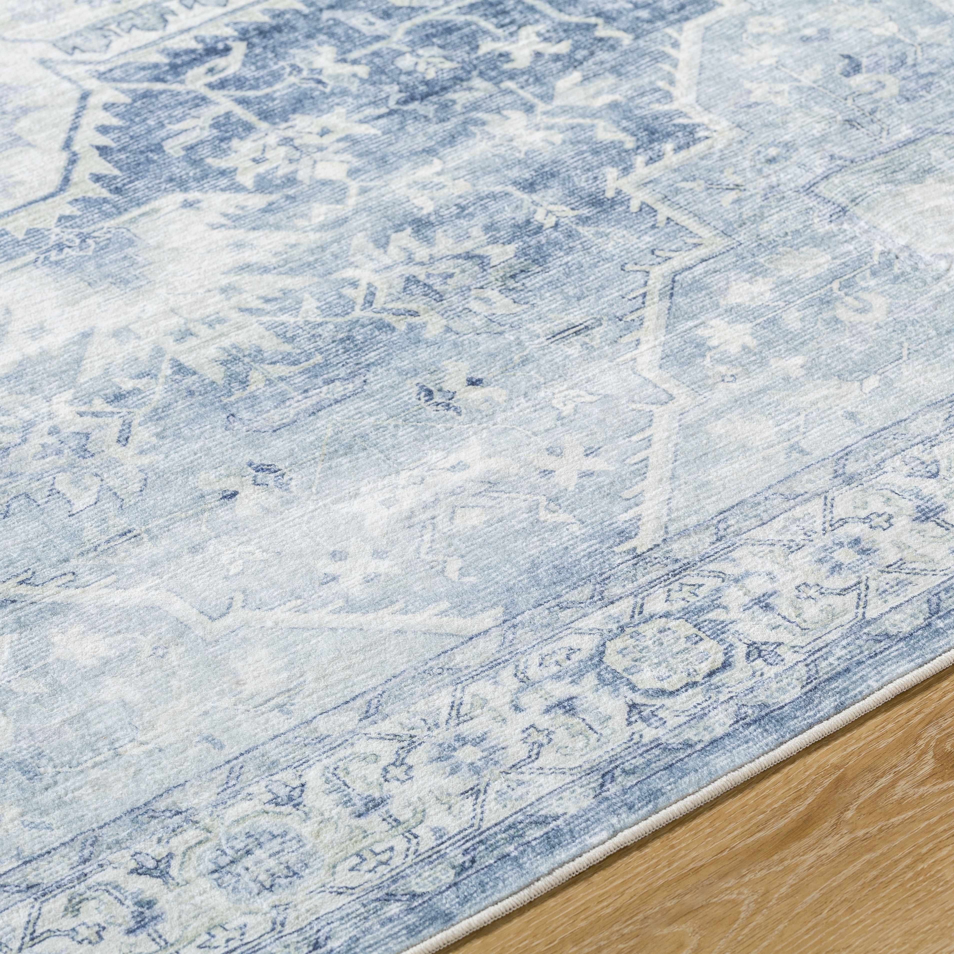 Close-up of a blue and white patterned rug on a wooden floor