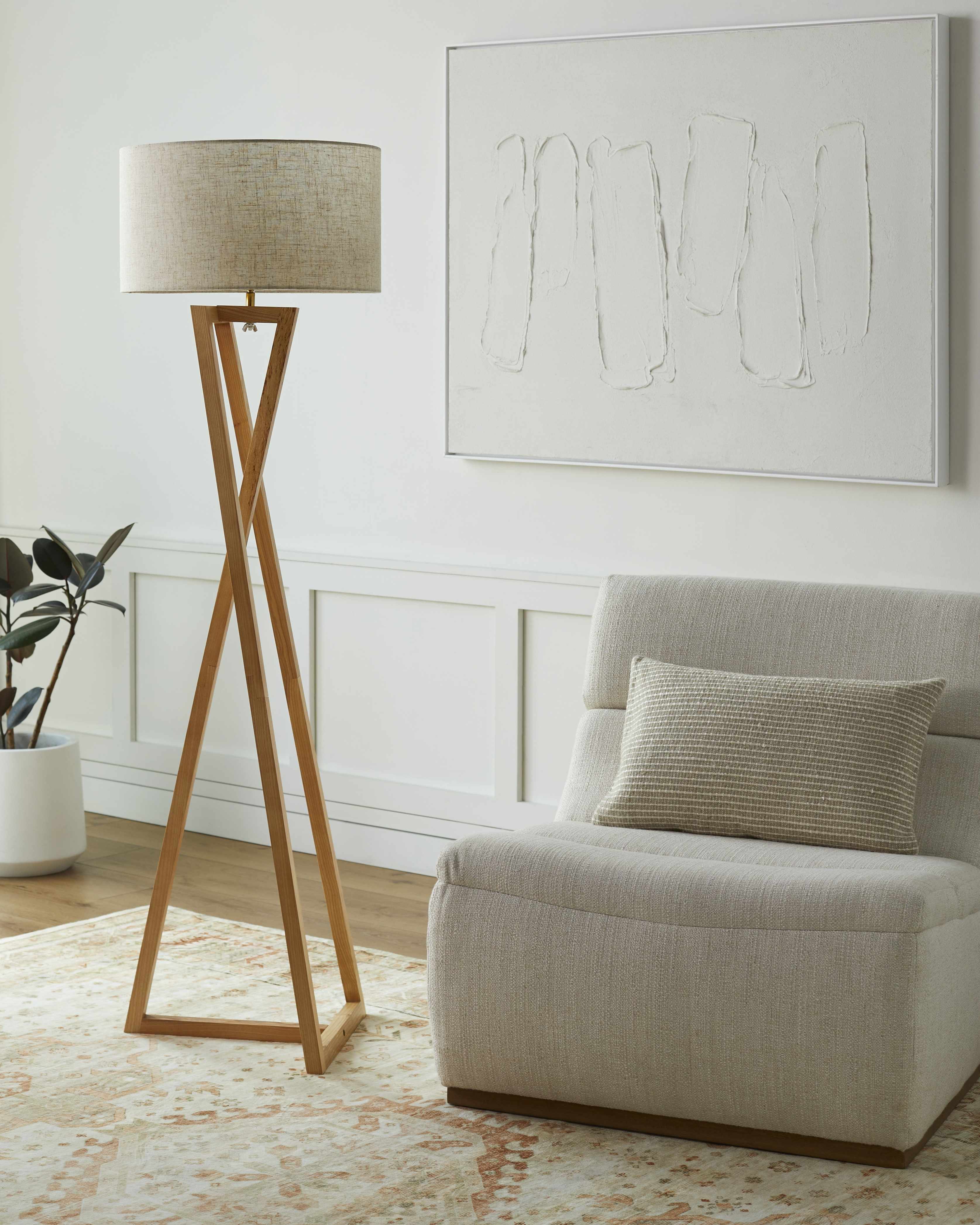 Modern living room with a beige sofa, floor lamp, and abstract painting.