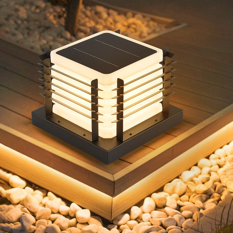 Solar-powered outdoor light fixture on a wooden deck with pebbles in the background
