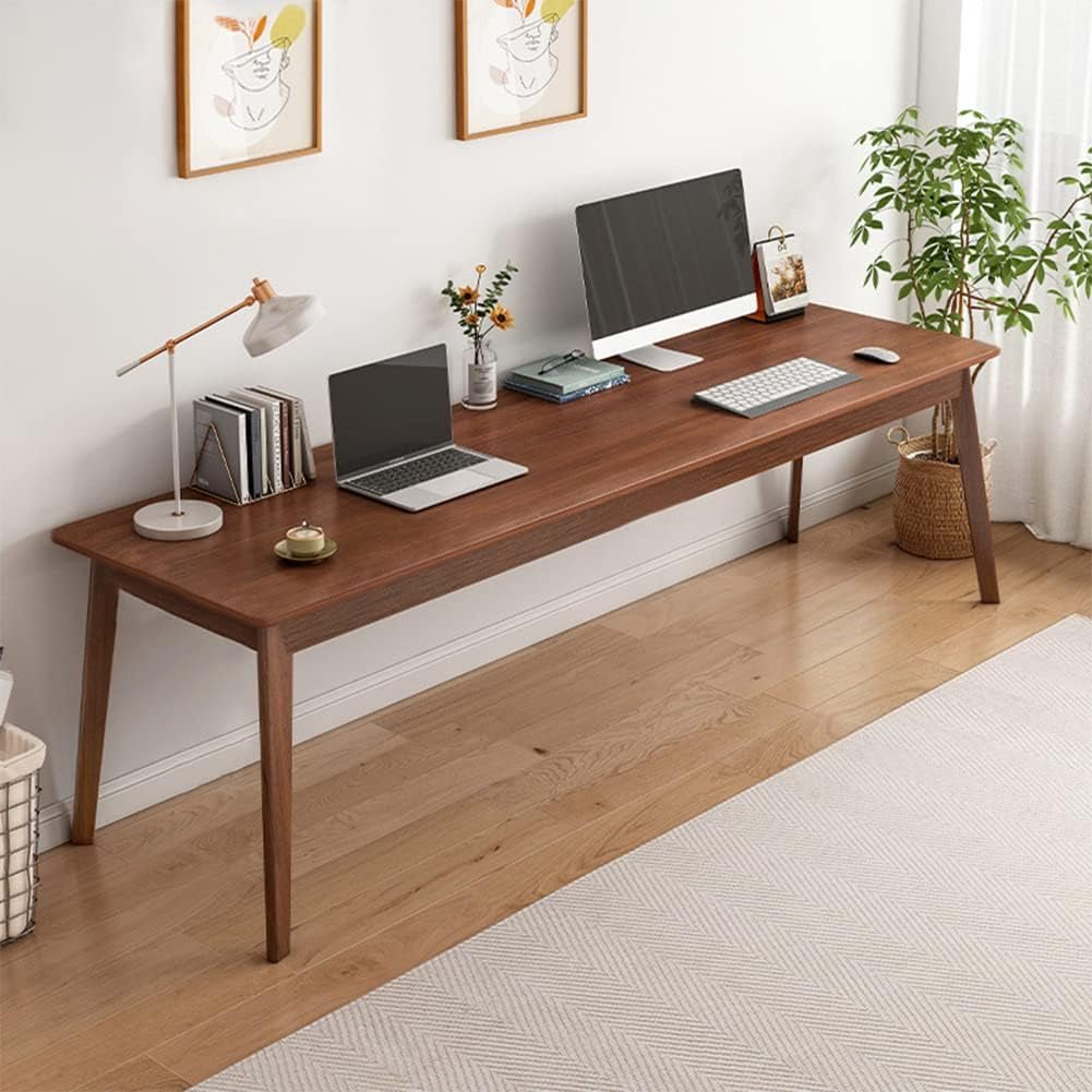 Wooden desk with laptop, monitor, and other items in a home office setting.