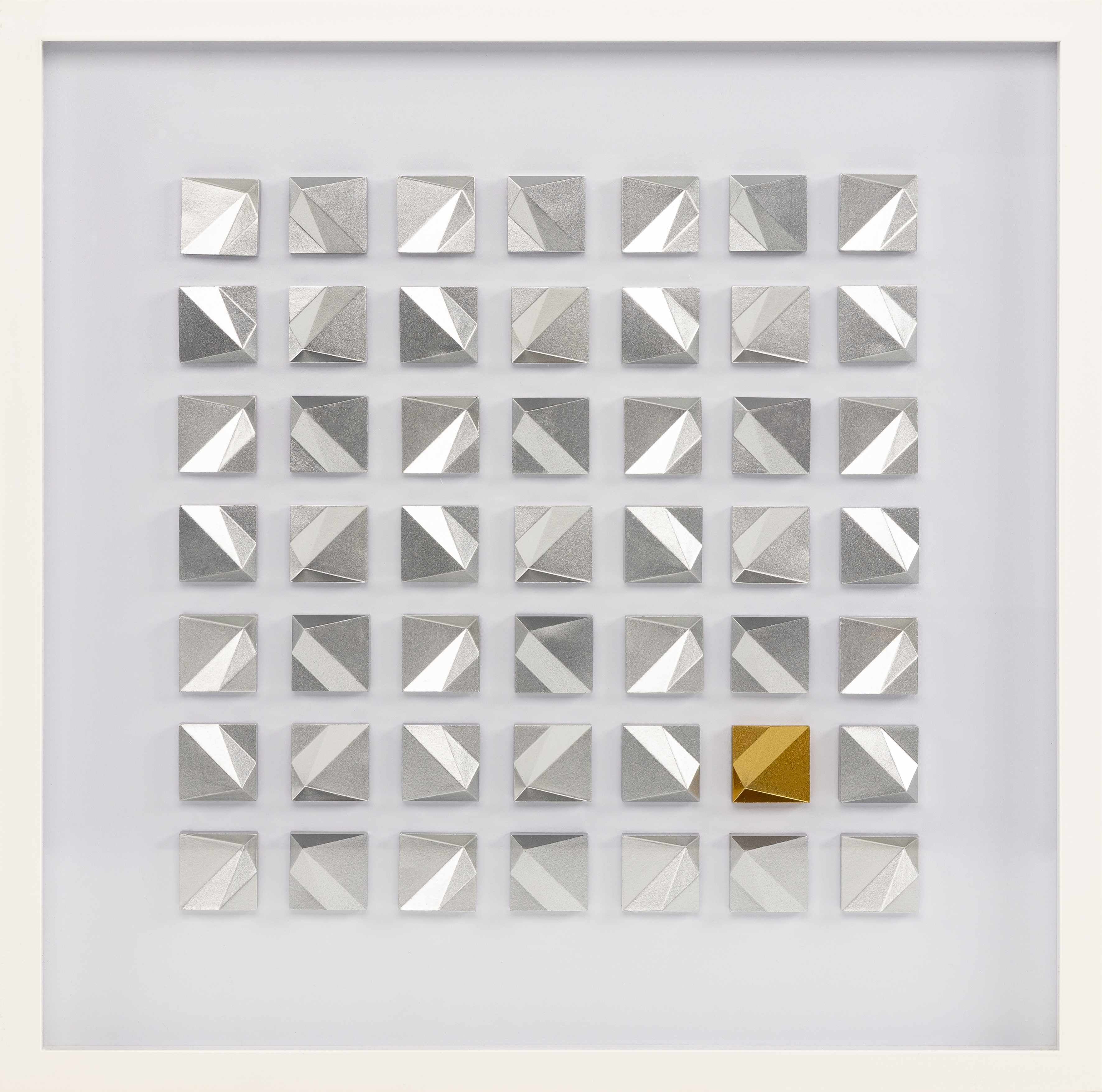 Grid of silver square tiles with a gold tile in the center on a white background