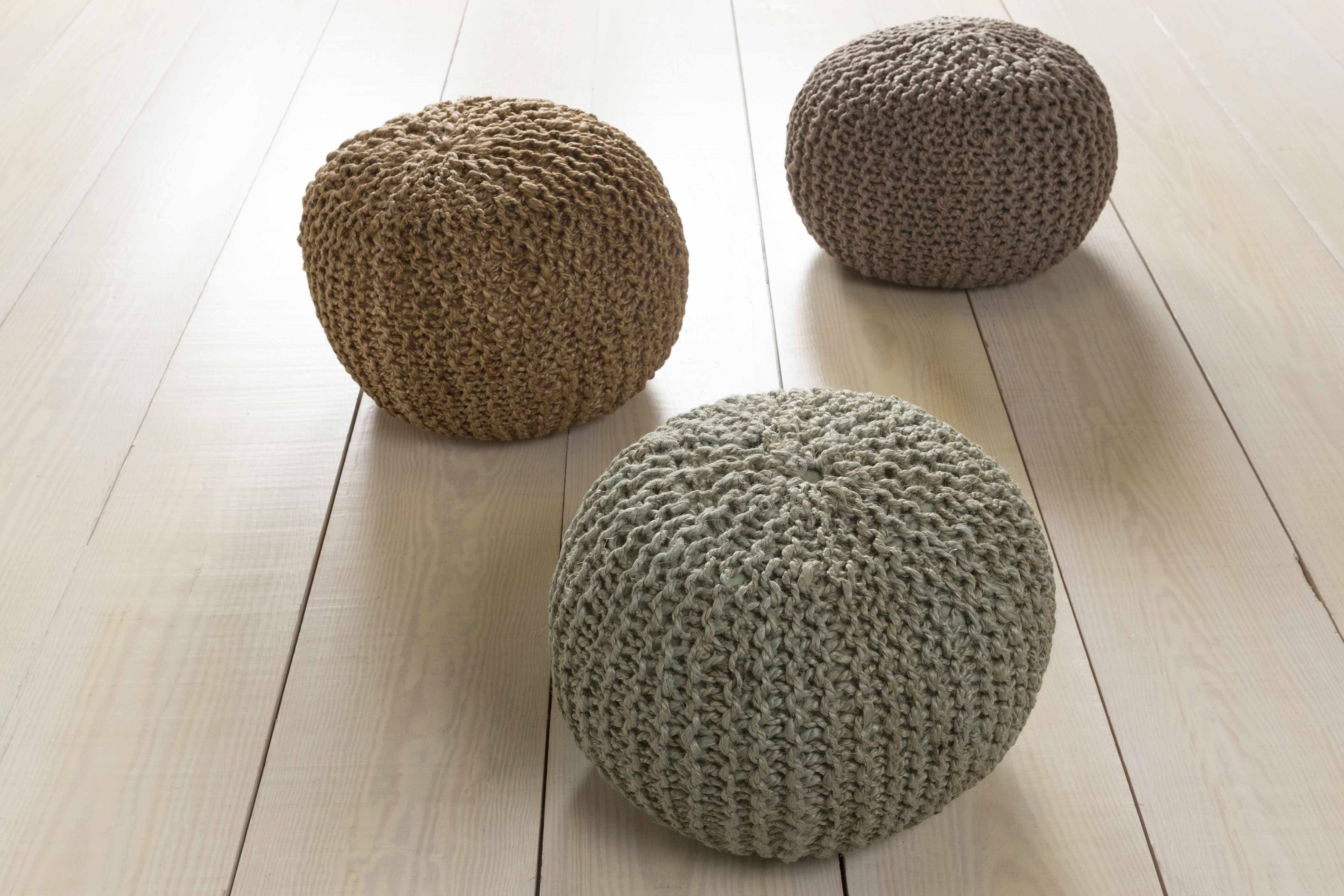 Three knitted poufs on a light wooden floor