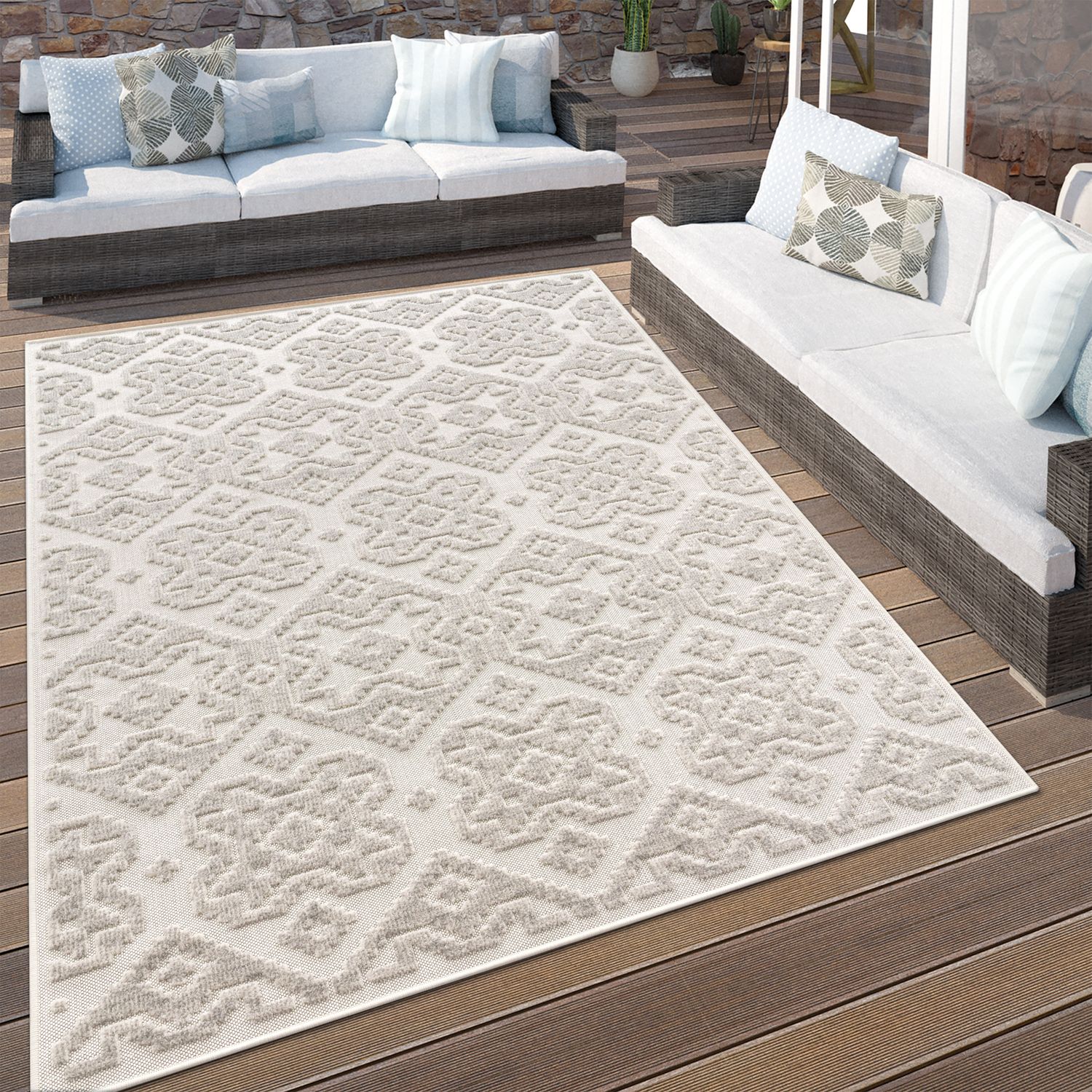 Patterned outdoor rug on a wooden deck with patio furniture.