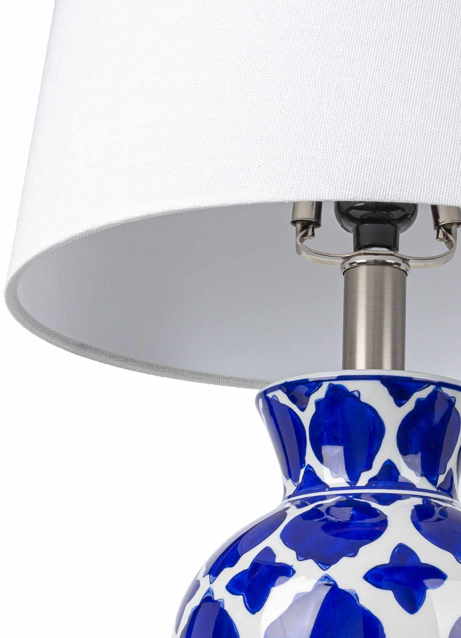 Table lamp with blue and white patterned base and white shade on a white background