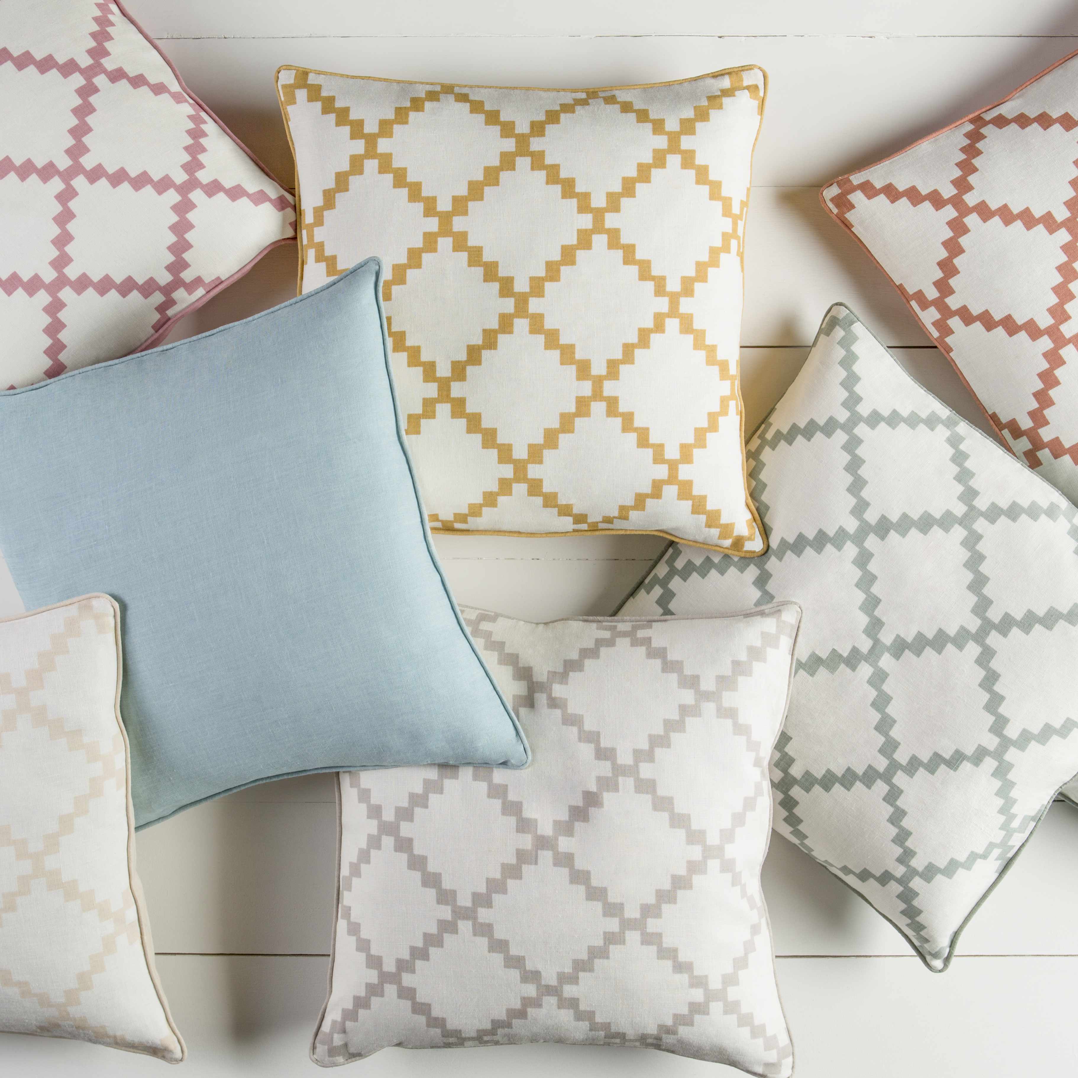 Collection of patterned cushions on a light wooden floor