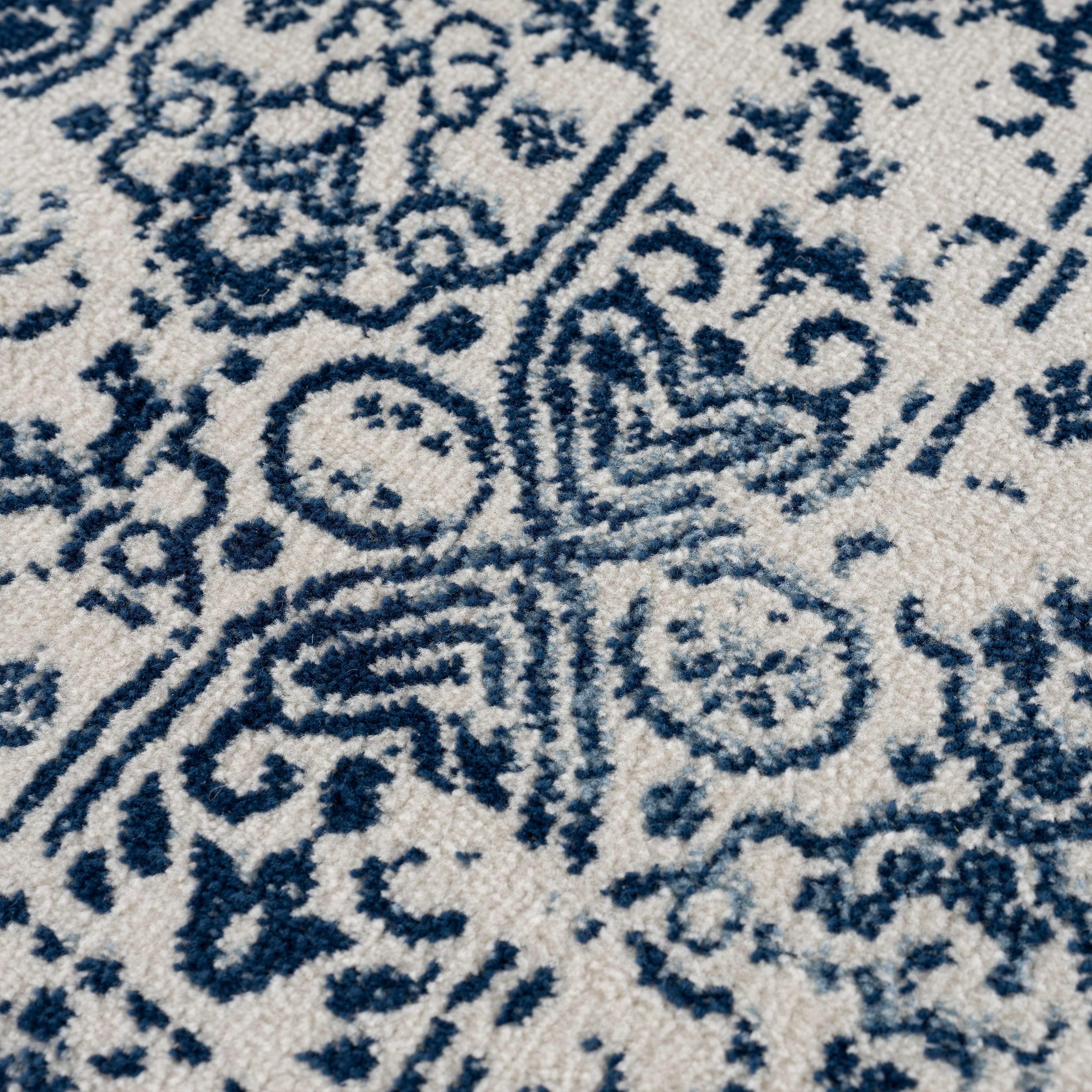 Close-up of a patterned rug with blue and beige design