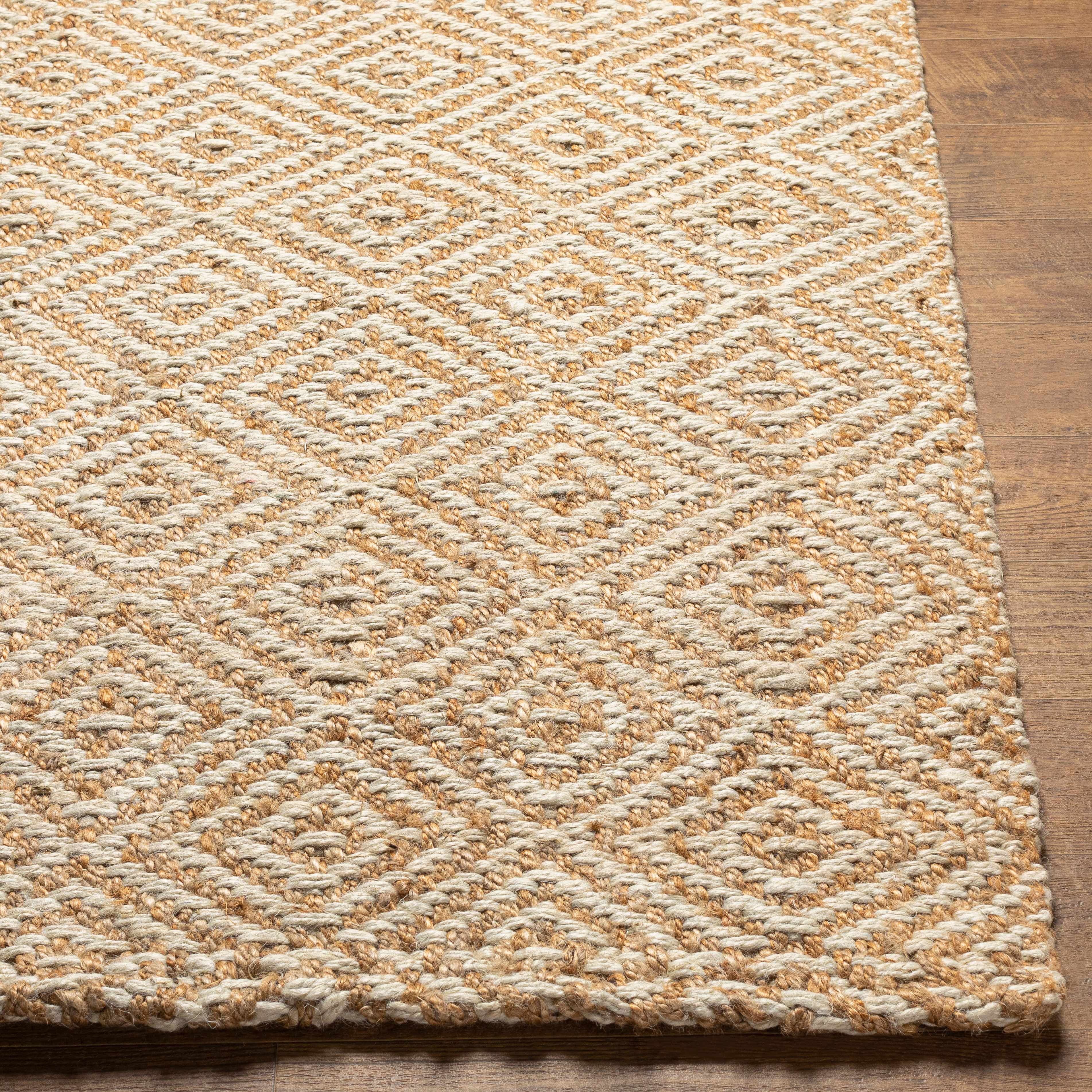 Textured beige and brown woven rug on a wooden floor