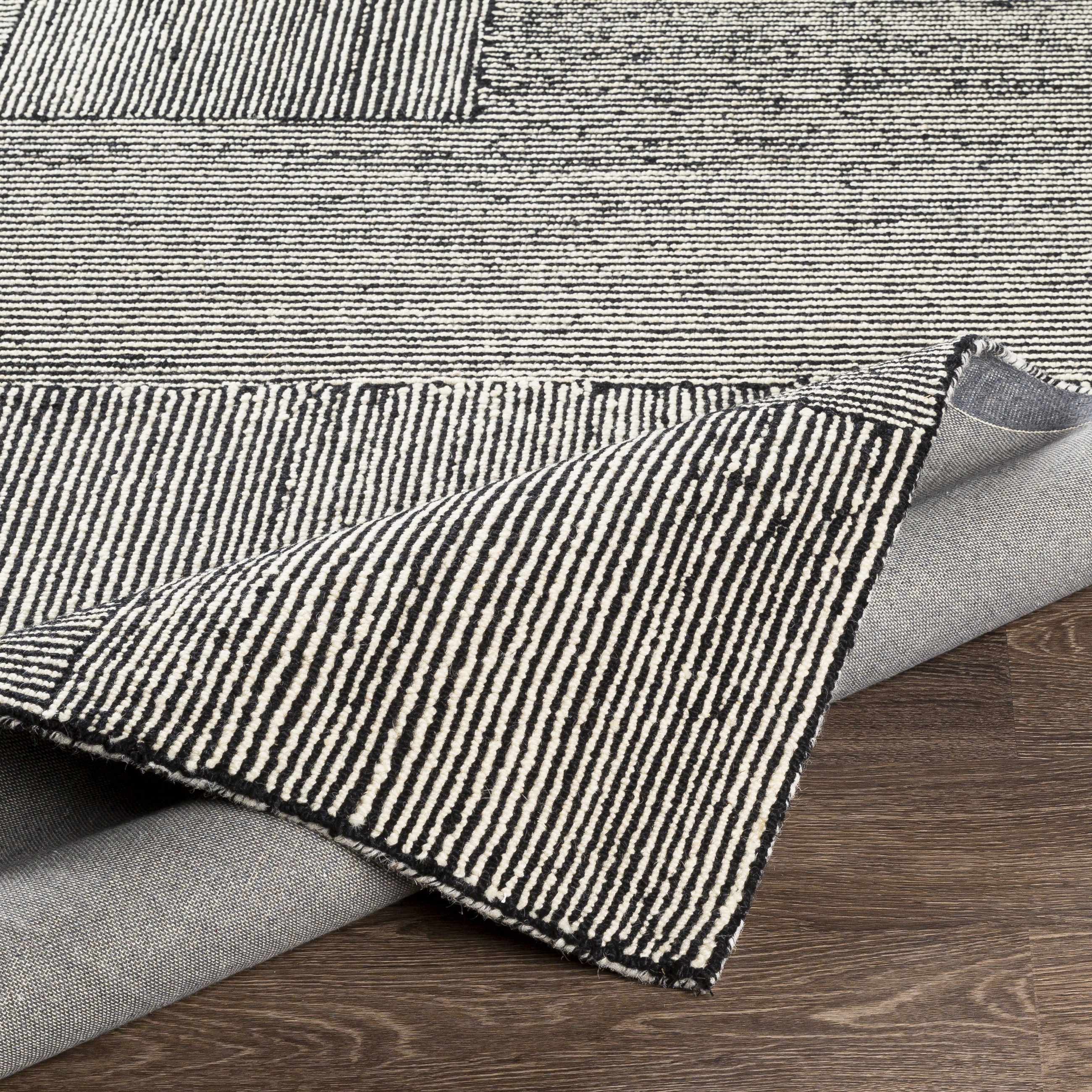 Textured fabric with black and white stripes on a wooden surface
