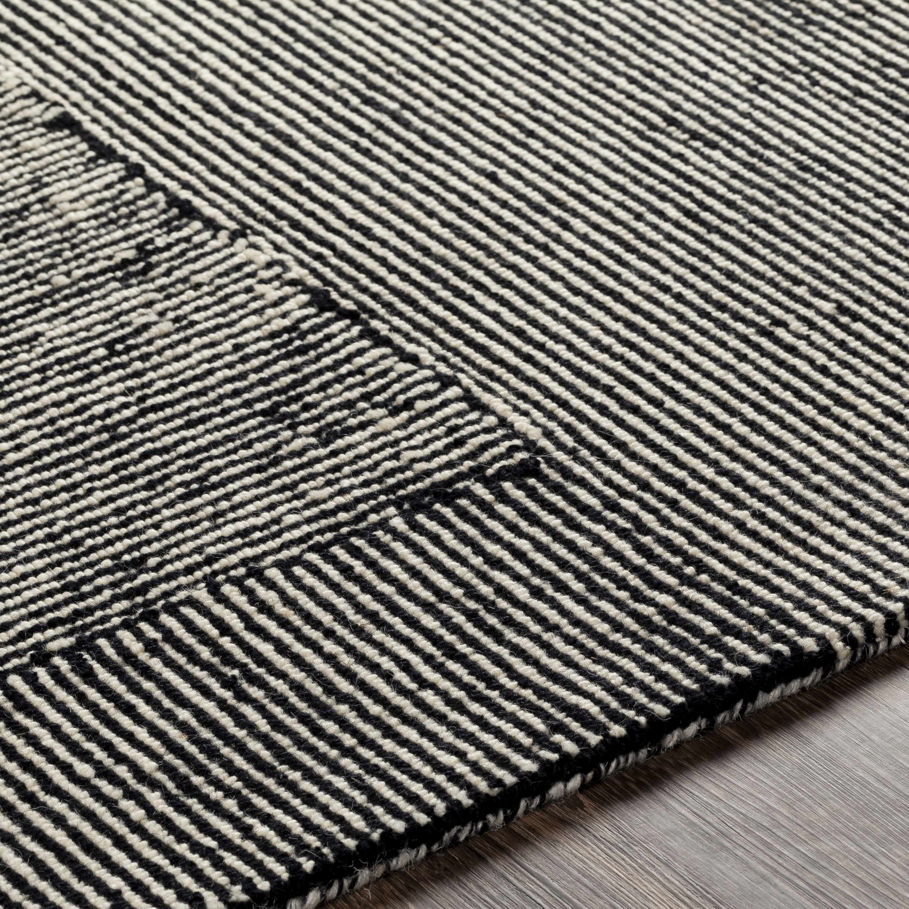 Close-up of a black and white striped rug on a wooden floor
