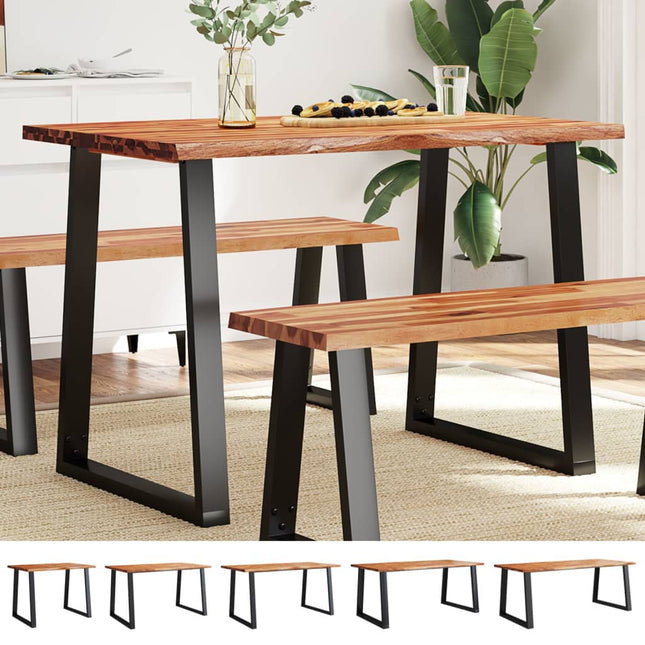 Wooden dining table with black metal legs and matching benches in a room setting.