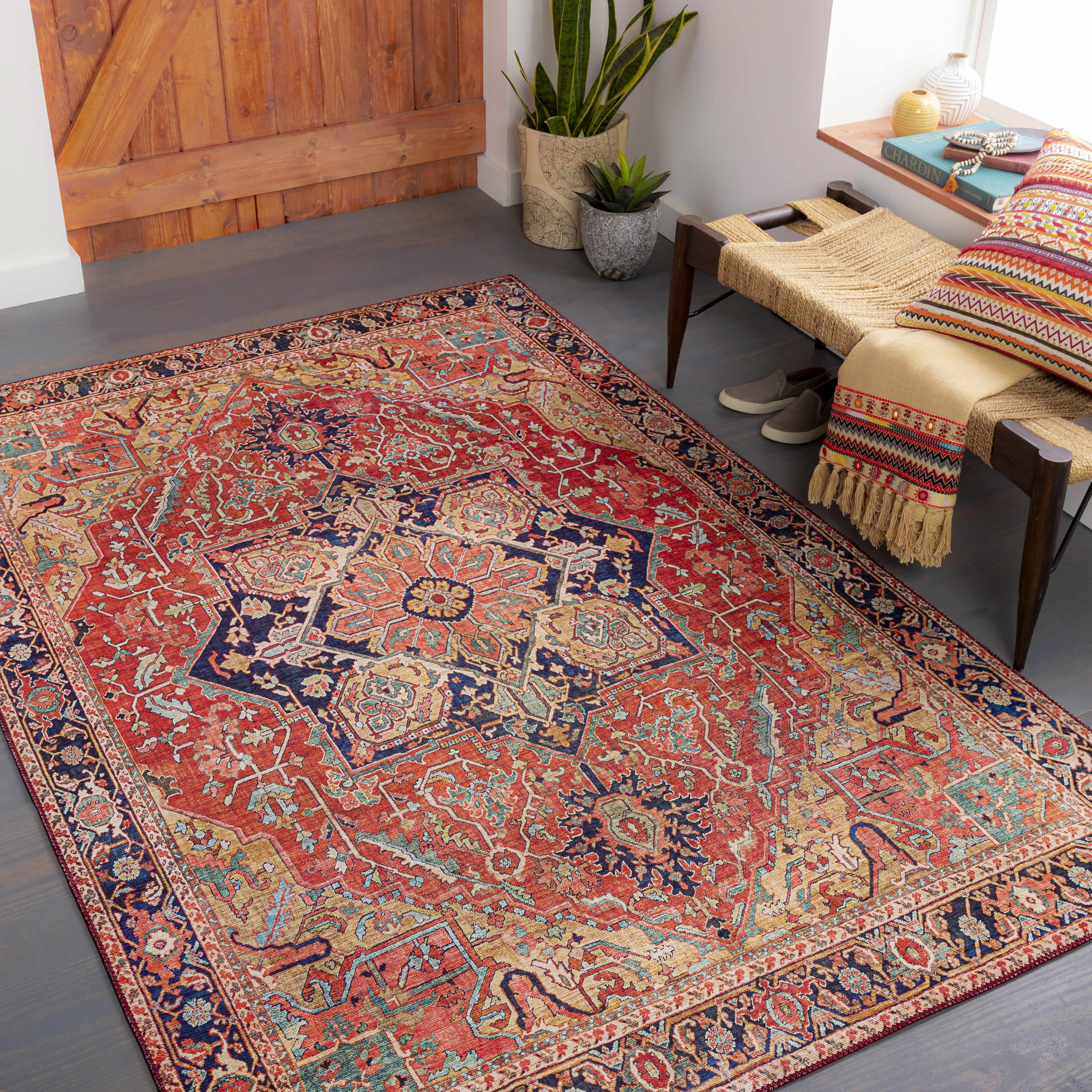 Decorative rug with intricate patterns in a room with a wooden bench and plants.