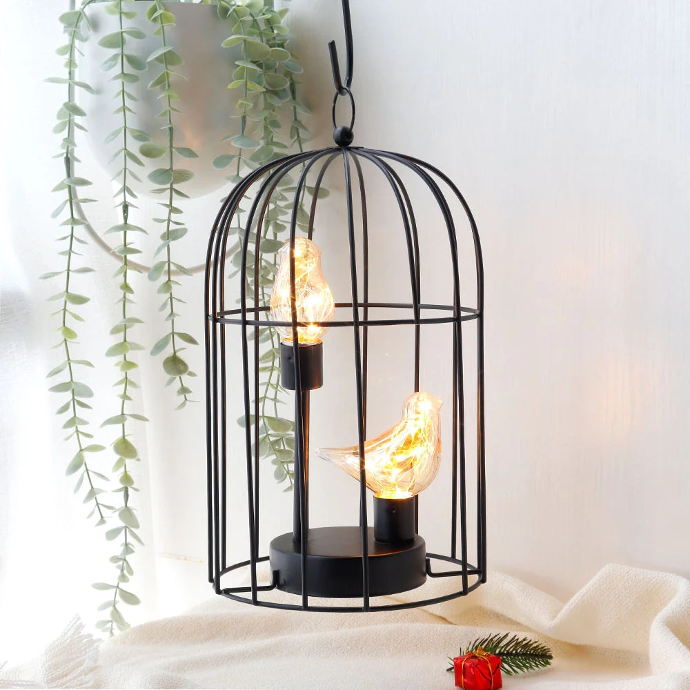 Decorative black metal cage with hanging light bulbs against a white background