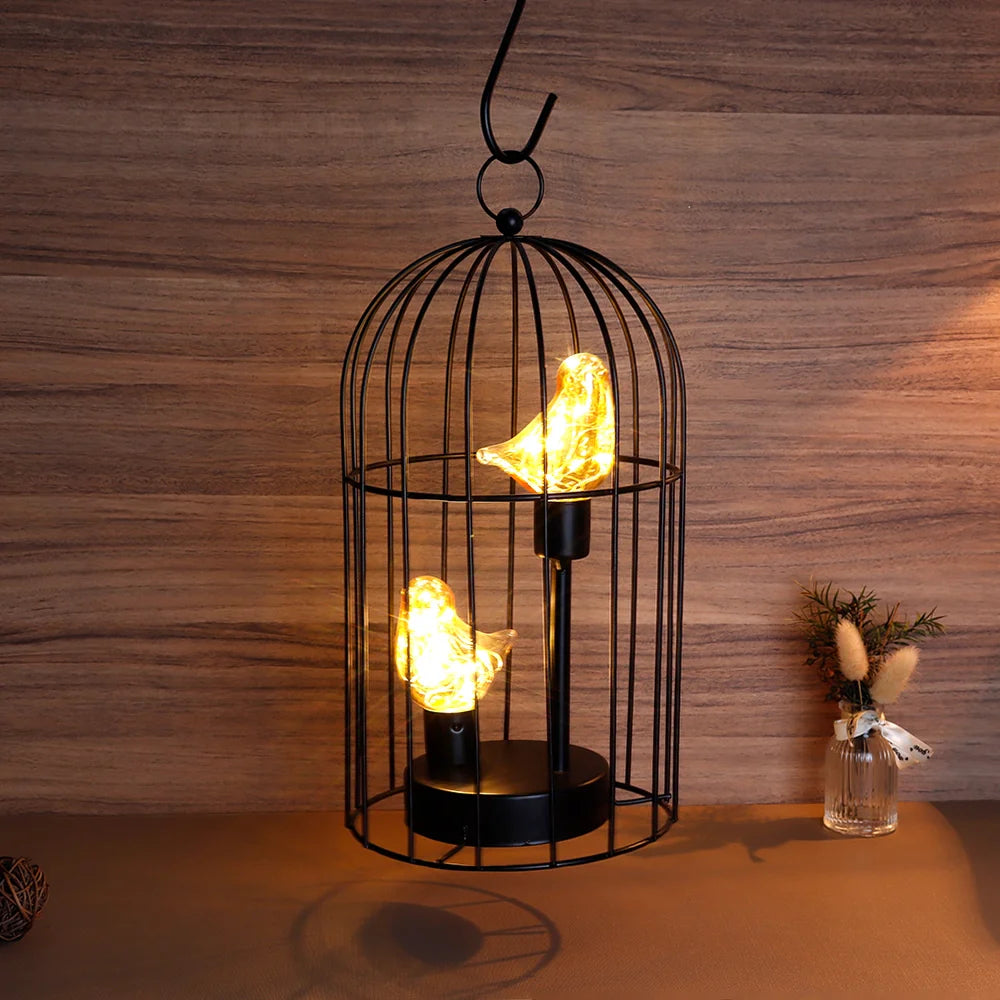 Decorative lamp with birdcage design and glowing bulbs on a wooden surface.