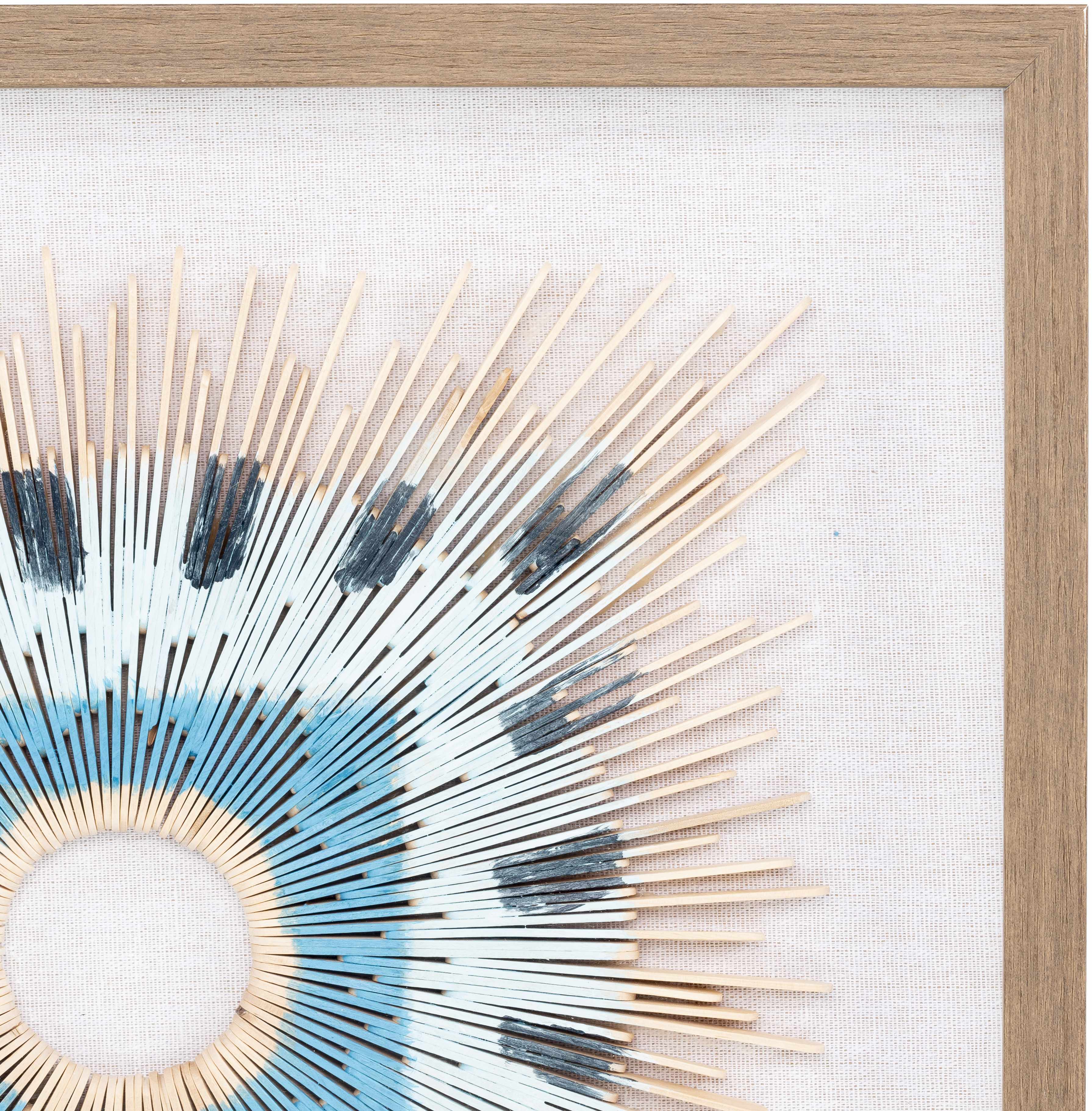Decorative wall art with a circular design featuring wooden sticks and blue accents on a white background.